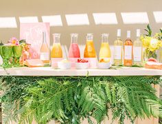 a table topped with lots of different types of juices and drinks on top of it