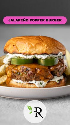 a burger with pickles and cheese on it sitting on a plate next to some fries