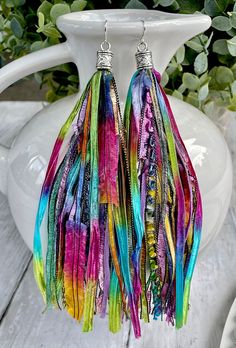 These vibrant tassel earrings will add the perfect pop of color to your wardrobe whether you're wearing a simple t-shirt and jeans or heading out in your favorite dress!  These fun earrings are made from carefully selected, high quality pieces of beautiful, rare novelty yarns.  The tassel part of the earring measures approximately 6 inches with a total drop length of 7 inches when including the earring end cap.  The end cap has a pretty antique heart pattern and the earring wire is stainless ste Bohemian Earrings For Spring Party, Bohemian Spring Earrings For Party, Bohemian Spring Party Earrings, Rainbow Fringe Dangle Earrings, Handmade Tassel Earrings For Spring, Multicolor Dangle Earrings For Spring, Bohemian Tassel Earrings For Party, Rainbow Dangle Earrings With Fringe, Colorful Summer Dangle Jewelry