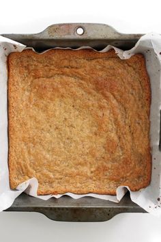 an uncooked cake in a pan on a white surface with paper around it