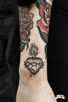 a woman's arm with a tattoo on it and roses around the wrist area