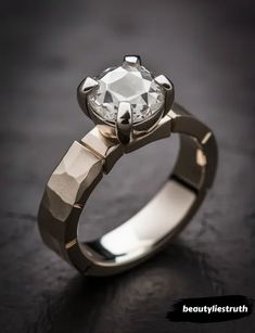 an engagement ring with a diamond in the center on a black surface, close up