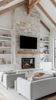 a living room with white furniture and a stone fireplace