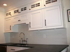 a kitchen with white cabinets and black counter tops