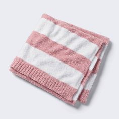 the pink and white striped towel is folded on top of it's own cloth