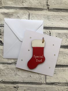 a greeting card with a stocking hanging from it's side, next to an envelope that says special dad