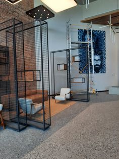 an office with chairs, desks and shelves in the middle of the floored area