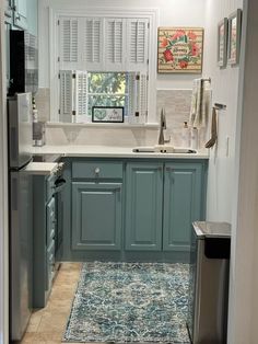 a kitchen with blue cabinets and an area rug