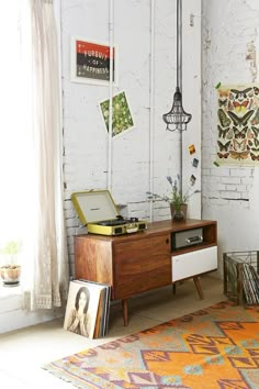 an old record player sits on top of a dresser in the corner of a room