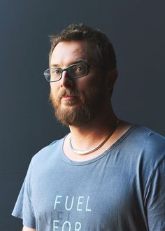 a bearded man wearing glasses and a t - shirt