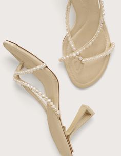 Cult Gaia Soriah Pearl Mule Heel Sandal in pearl. Mule silhouette. Pearl covered thin straps. Shiny metal heel. Negative space heel. Rubber sole. 4" inches. Upper: 100% Polyester 100% Real Pearl. Sole: 100% Reconstituted Leather. Imported. Shoes With Pearls, Mule Silhouette, Glass Heels, Mule Heel, Pearl Sandals, White Wardrobe, European Wedding, Sandal Shoes, Shoe Inspo