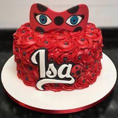 a red cake decorated with ladybug eyes and the word las written in black