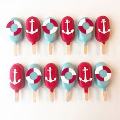 six lollipops with red, white and blue designs are arranged in the shape of an anchor