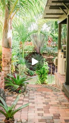 a patio with brick pavers and palm trees