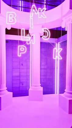 an empty room with columns and neon lights