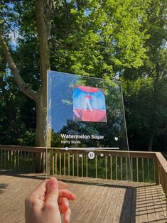 someone is holding their hand out to take a picture of the watermelon square sign