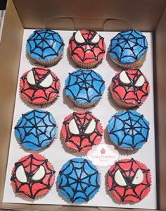 a box filled with cupcakes decorated like spiderman's web designs on top of each other