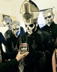 a group of people in costumes standing around each other and one person holding a can