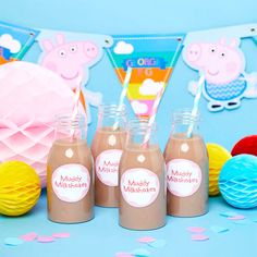 three jars filled with chocolate milk sitting on top of a table next to paper decorations