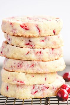 a stack of cranberry shortbread cookies sitting on top of a cooling rack