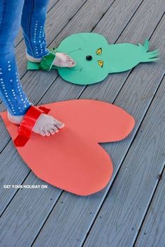 a person standing on top of a wooden floor next to two paper cut out birds