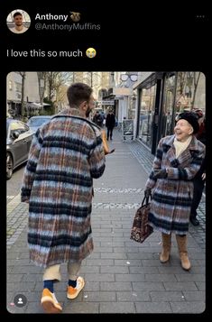 two people walking down the street talking to each other