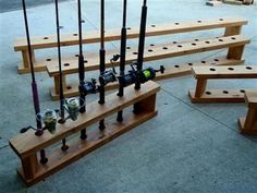 several wooden benches with fishing rods and reels attached to them on the concrete ground