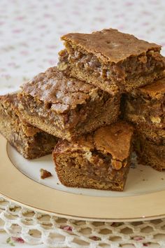 a stack of brownies sitting on top of a white plate