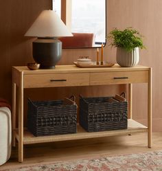 two wicker baskets under a table with a lamp