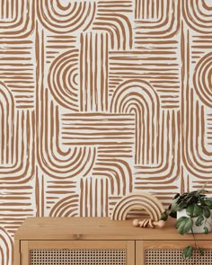 a wooden cabinet sitting in front of a wall with a brown and white pattern on it