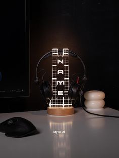 a computer mouse sitting on top of a desk next to headphones and a lamp