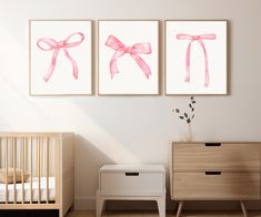 two pink bows are hanging on the wall next to a crib with a baby's bed