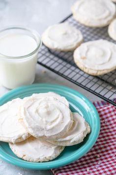 some cookies are on a blue plate next to a glass of milk