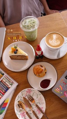 a table topped with plates and cups filled with desserts next to a laptop computer