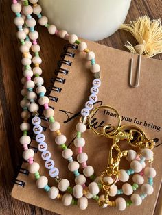 Show your appreciation for the educators in your life with our "Handmade Teacher Pastel Double Beaded Lanyard." Crafted with love and attention to detail, this colorful badge holder not only keeps essentials secure but also adds a touch of personal flair to any outfit. Each lanyard is made using high-quality pastel beads, creating a vibrant and cheerful accessory that stands out in a crowd. Measuring approximately 20 inches in length, our lanyard is the perfect size for holding ID badges, keys, and other small items frequently used by teachers and professionals. The beads are strung on a durable, yet comfortable cord that's designed to withstand daily wear and tear. This user-friendly piece makes it easy to keep your essentials organized and stylish. The "Handmade Teacher Pastel Double Bea Multicolor Craft Supplies For End Of School Year, Multicolor Personalized Lanyards With Round Beads, Personalized Multicolor Lanyards For Teacher Appreciation, Handmade Multicolor Badge Holders As Gifts, Handmade Multicolor Badge Holders, Personalized Multicolor Lanyards With Round Beads, Multicolor Handmade Craft Supplies For Teacher Appreciation, Handmade Multicolor Craft Supplies For Teacher Appreciation, Personalized Multicolor Badge Holders For Everyday Use