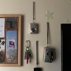 there are many items hanging on the wall next to each other, including a camera and keys