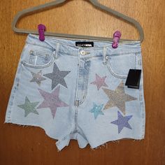 These Sparkling Sequin Star Shorts Are Just Too Cute And Perfect For Summer Festivals And Outings! Unique And Adorable! The Multi-Color Stars Stand Out Even More Against The Light-Denim Background. Minimal Stretch Measurements: Waist Lying Flat - 15in Length - 14in Inseam - 3in Materials: 99% Cotton 1% Spandex Light Denim Shorts, Denim Background, Background Minimal, Army Green Jeans, Distressed Bermuda Shorts, Fashion Nova Shorts, Cuffed Denim Jeans, Star Shorts, 70 Fashion