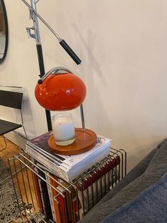 an orange lamp sitting on top of a stack of books