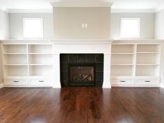 empty living room with fireplace and built in bookcases