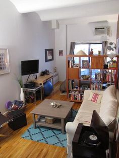 a living room filled with furniture and a flat screen tv on top of a wooden floor