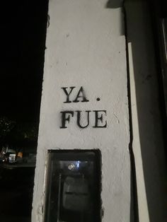 the word ya fue is written in black on a white stucco wall with an electrical outlet