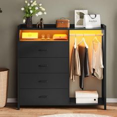 a black and yellow cabinet with clothes hanging on the door, next to a white rug