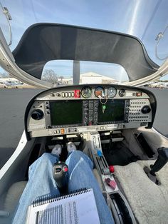 the pilot is sitting in the cockpit of an airplane with his feet on the ground