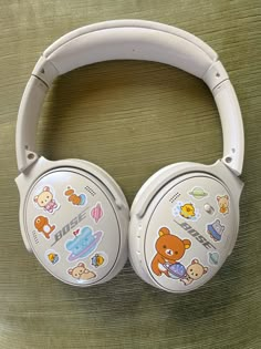 a pair of headphones sitting on top of a wooden table covered in stickers