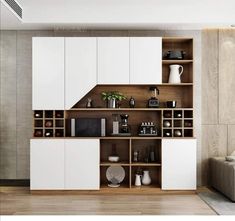 a kitchen with white cabinets and wooden flooring in front of a wall mounted oven