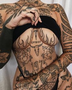 a woman with tattoos on her chest and arms