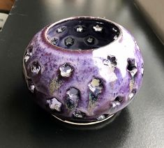 a purple vase sitting on top of a table