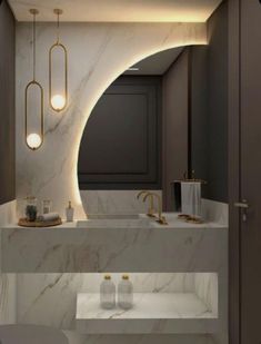 a bathroom with marble counter tops and gold fixtures on the wall, along with two sinks