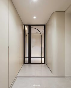 an empty hallway with white walls and black doors