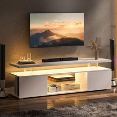 a living room with a flat screen tv mounted on it's wall and an entertainment center